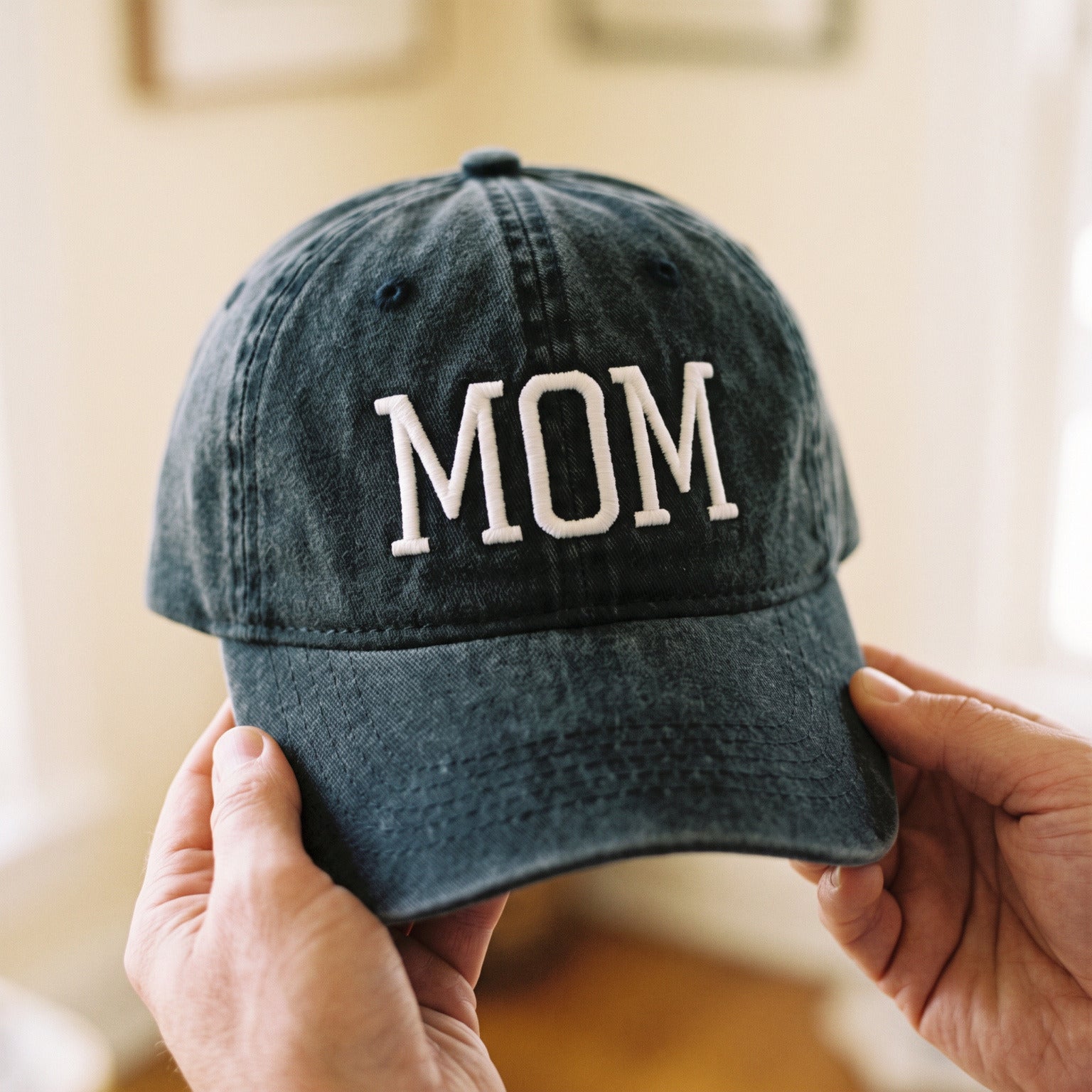 Close view of a Black MOM cap showing the embroidered lettering and cotton texture