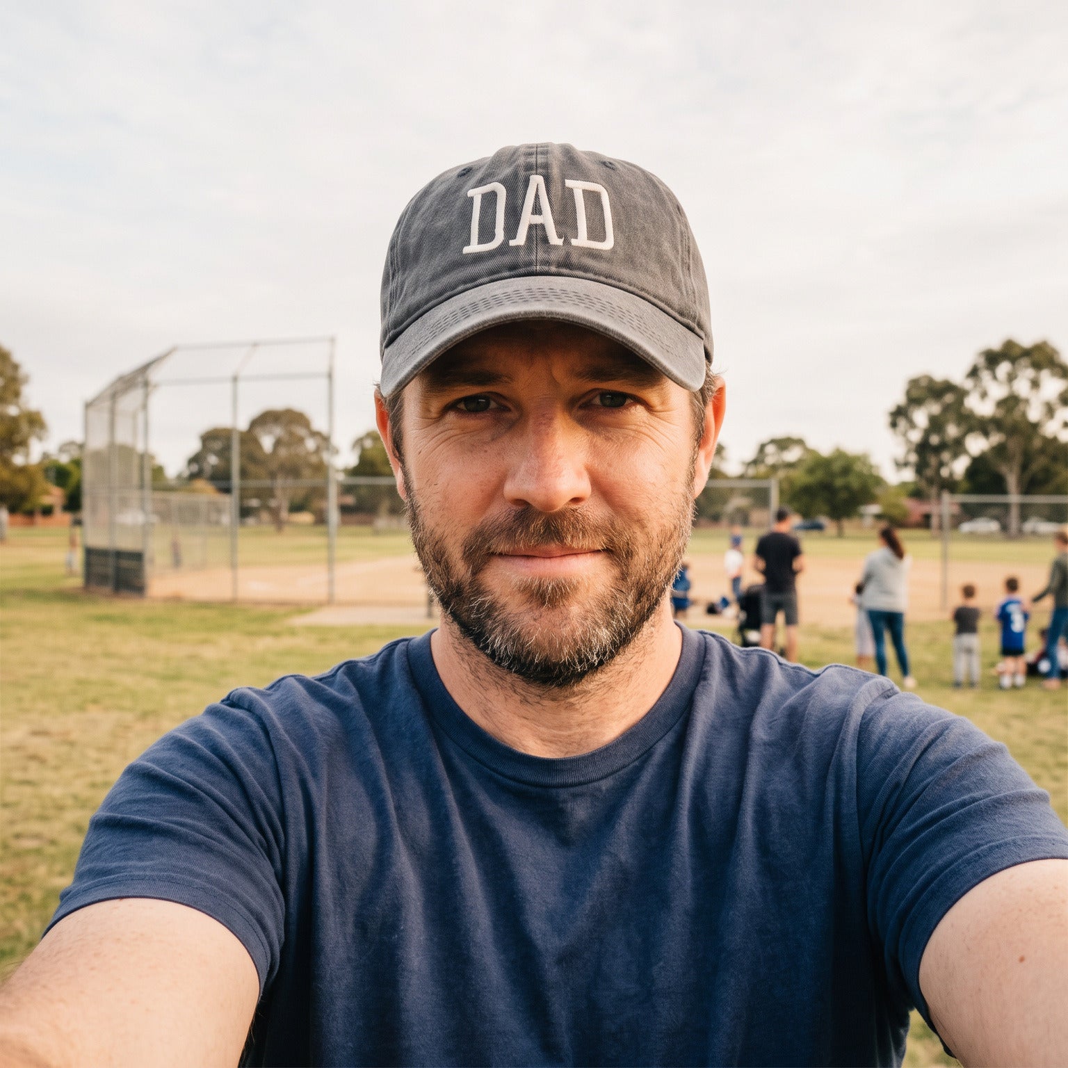 Bearded dad taking a casual sports-side selfie in a Grey DAD cap