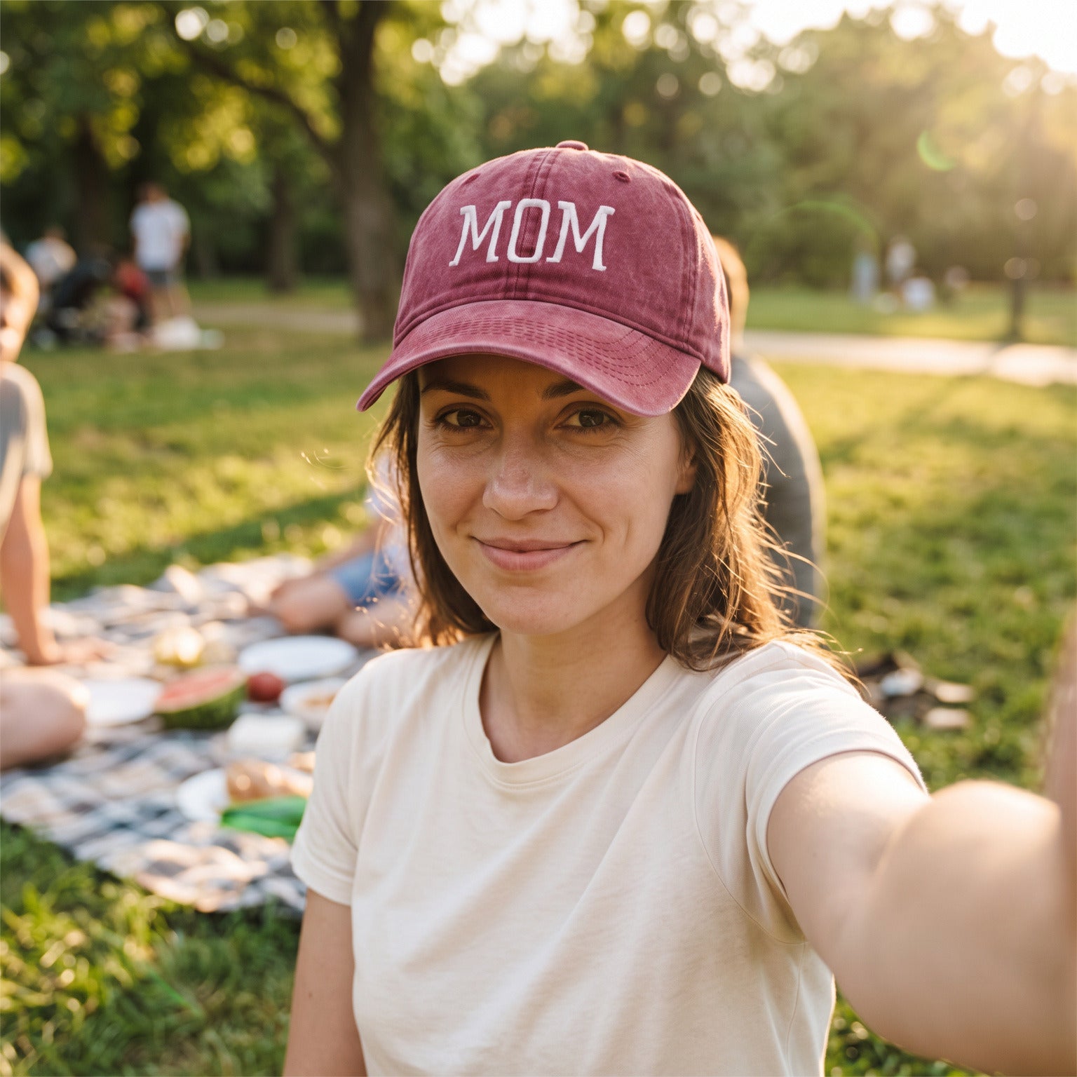 Mum taking a relaxed selfie wearing her MOM cap outdoors